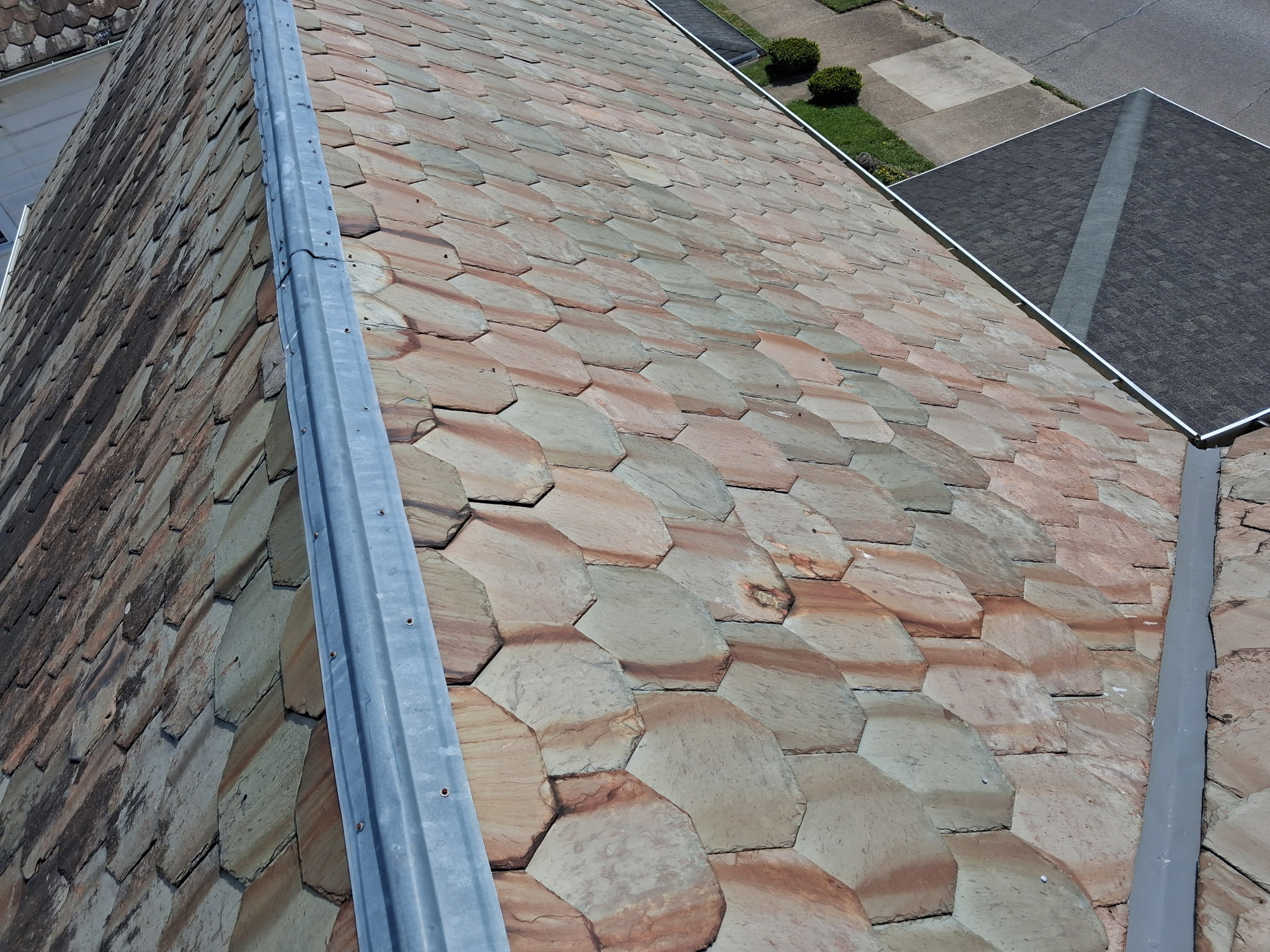 Multi-color fish-scale slate roof installed by Winegardner Roofing showing the timeless character of a properly installed slate roof