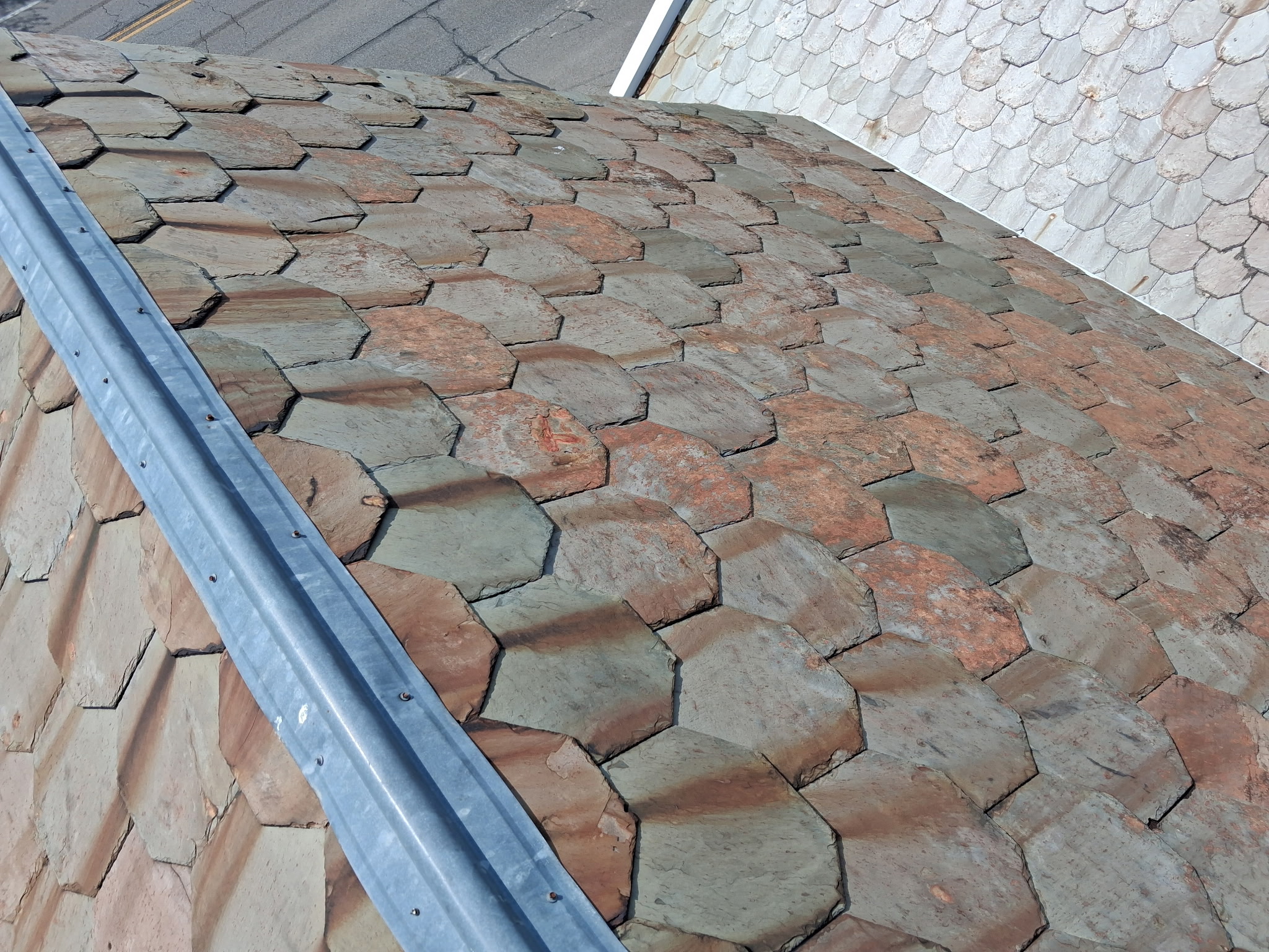 EPDM rubber roofing installation on a flat roof section with plumbing penetrations and watertight seal