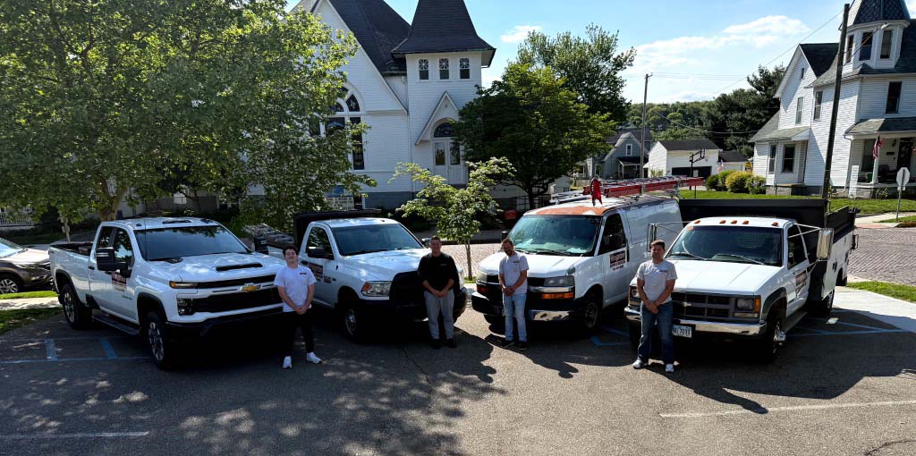 Winegardner Roofing and Remodeling team standing with company service vehicles in Bremen Ohio